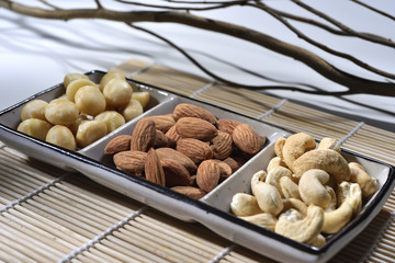 almond and cashew in the plate on the bamboo mat