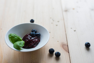 Jam of blueberries on a light wooden table for a delicious breakfast
