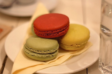 Three colorful macarons on a plate. Selective focus.