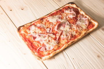 Crispy gold baked pizza slices on a wooden table.