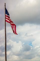 a great star flag on a tall wooden pole waving prouldy in the sky