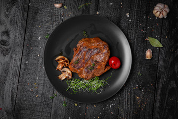 Beef steak on the bone. Octoberfest party dinner. Festive table with delicious food on black boards.