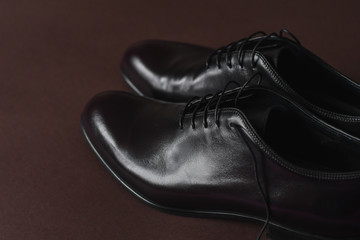 Close of fashionble men dark red leather shoes on dark background. 