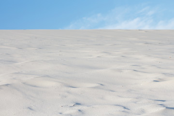 White sand in the desert and blue sky, selective focus.