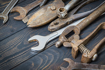 Old tools stacked after work on black vintage wood background
