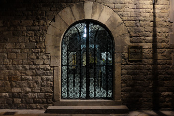 Barcelona, Spain - April 26: Detail of the metal gate in the night street on April 26, 2017 in Barcelona, Spain.
