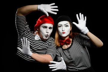 Funny mime artists on black. Striped shirts, white gloves and berets