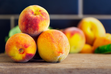 Close up of fresh homegrown peaches on rustic wooden chopping block