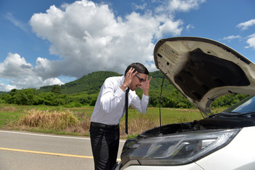 Anxious businessman full of shock, broken cars on Asian roads