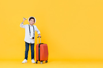 Smiling Asian boy going on vacation holding toy airplane