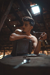 Gang member sitting at naked table.