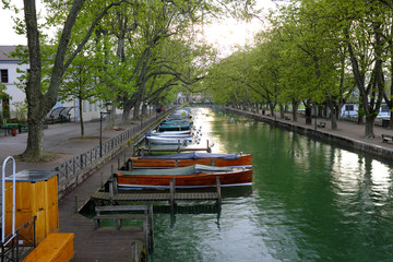 Obraz premium Beautiful view of the Canal du Vasse with many boats and trees on April 28, 2017 in Annecy, France.