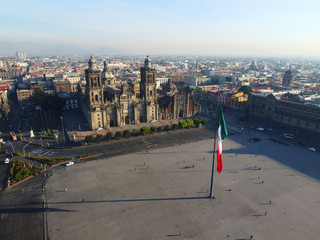 Mexico National Flag on Zocalo Constitution Square and Metropolitan Cathedral aerial view, Mexico City CDMX, Mexico. Historic center of Mexico City is a UNESCO World Heritage Site since 1987.