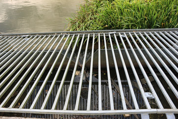 Grill covering weir in lake