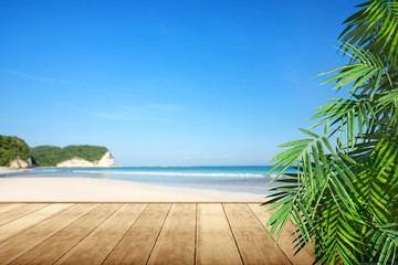 Wooden floor with oceanview and green palm leaf