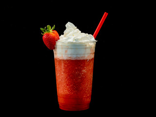 Fresh strawberry fruit smoothie in a clear plastic cup with whipped cream.