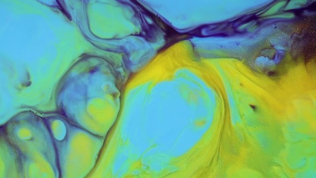 Abstract texture flowing in chaotic. Fluid art painting. Modern fluid painting artwork. Colourful liquid paints with acrylic spreading flowing. Yellow, green and blue multicolored surface