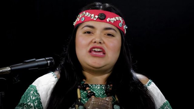 close up of young woman Shaman ,with sahumerio in the hands , curandera, Olmec facilitator, Teotihuacana, Xicalanca - Toltec in black background, with pre-Hispanic dress