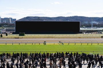 Crowd people watching monitors at racetrack
