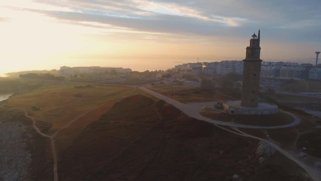 The beautiful tall lighthouse, Coruna Torre Hercules, Overlooking and facing the Sunset of North Atlantic coast of Spain- aerial shot