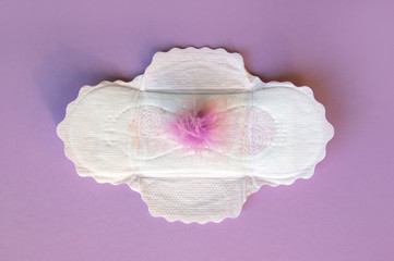 Menstrual pads with a fluff on a lilac background.