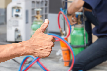 Technician man hand with clipping path giving thumb up, Over blurred repairman on the floor fixing air conditioning system background