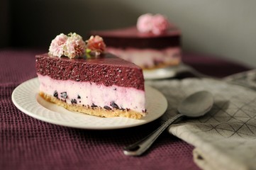 Obraz na płótnie Canvas Pieces of no baked blueberry cheesecake on white plate with purple towel
