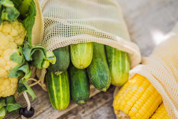 Different vegetables in reusable bags on wooden background. Zero waste concept