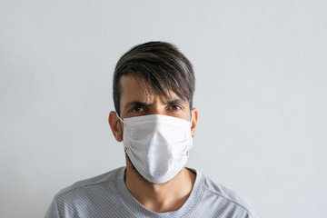 Angry man wearing a white medical mask.