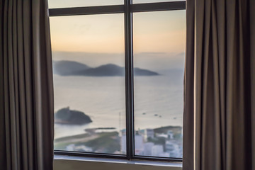 View of tropical beach through hotel window