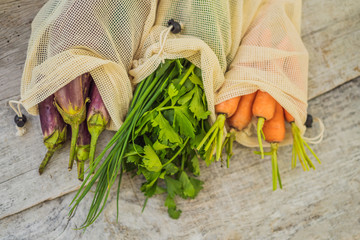Different vegetables in reusable bags on wooden background. Zero waste concept
