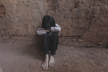 poor child sitting alone in old room.concept for bullying, depression stress or frustration.