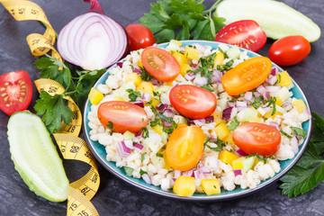 Salad with vegetables and bulgur groats and tape measure. Healthy meal containing natural vitamins and minerals