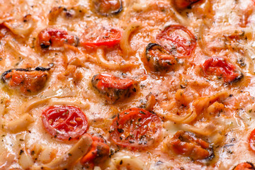 Tasty sliced pizza with seafood and tomato on a concrete background