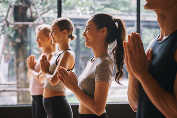 Group of young people practicing yoga In the prayer position at gym, Concept of relaxation and...