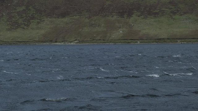 Abstract shot of a lough with little waves in Connemara, Ireland. Windy weather. Very flat composition.
