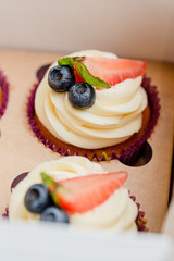 cupcakes with strawberries and blueberries in a box