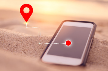 Smart phone on tropical sunset beach with gps navigator icon background. Technology business and travel holiday concept.