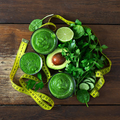 Green detox smoothie with measuring tape on wooden background detox juices concept