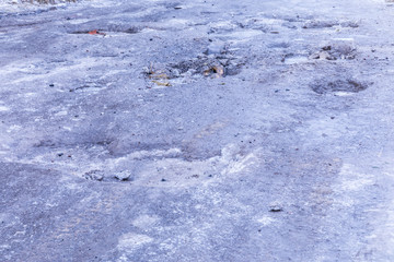 The bad asphalt winter road or way with ice, snow, puddles, pools, mud and slush
