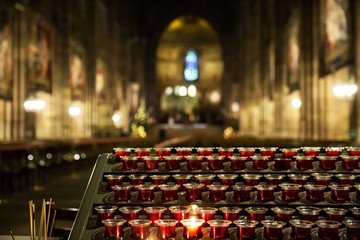 Lighting candles in a catholic temple .