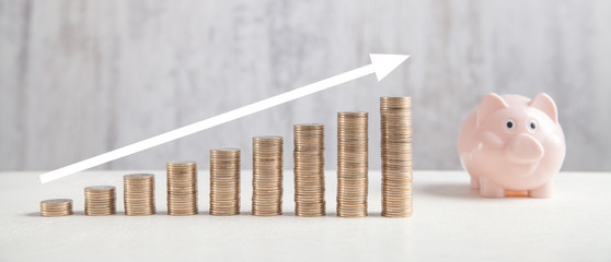  Coins, piggy bank on white table with a growth arrow.