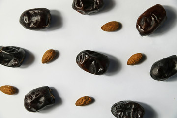 Dried dates fruits with almond on white background. Minimal healthy sweet food, studio shooting, flat lay, top view