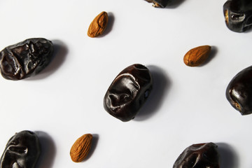 Dried dates fruits with almond on white background. Minimal healthy sweet food, studio shooting, flat lay, top view