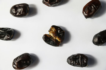 Open dried dates fruits on white background. Minimal healthy sweet food, studio shooting, flat lay, top view