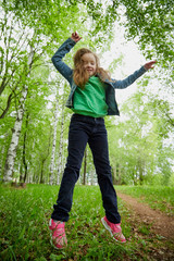 Playful funny little girl with long hair in a summer park