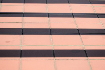 Brown tile on the floor with stripes of shadow on it. Abstract background