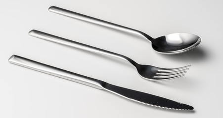 Spoon, fork and knife on a white background