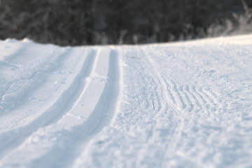 Fototapeta na wymiar Ski track in snow. Hilly snowy surface. Active winter holiday concept. Stock photo for web and print, background, wallpaper