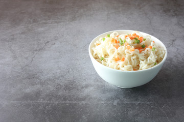 Instant noodles in a bowl isolated on dark background.